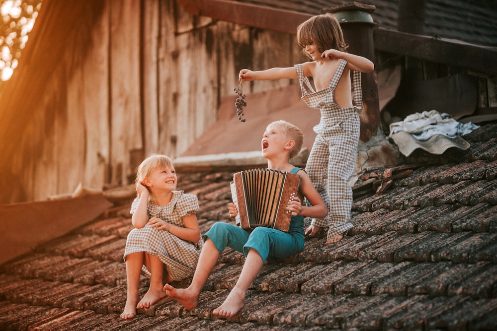 a group of children sitting on top of a roof