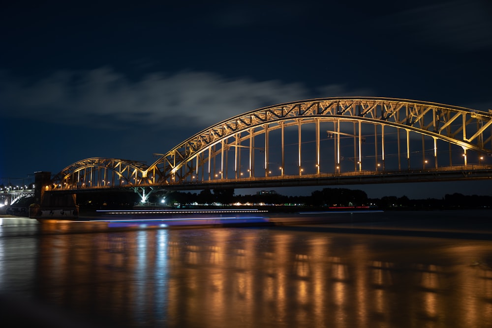 white and blue bridge over river during night time