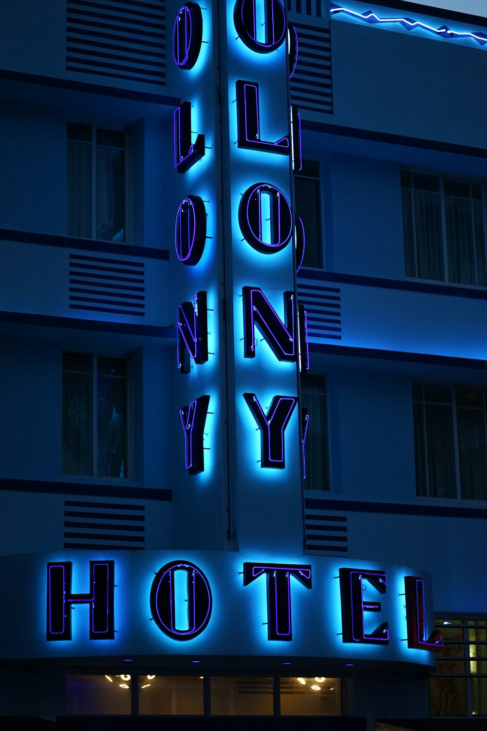 a very tall building with a neon sign on it's side