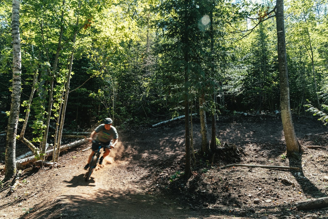 man in black shirt riding bicycle on forest during daytime