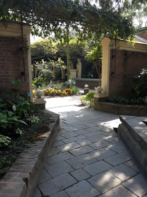 A sunlit garden pathway lined with blooming flowers, perfect for a romantic stroll.
