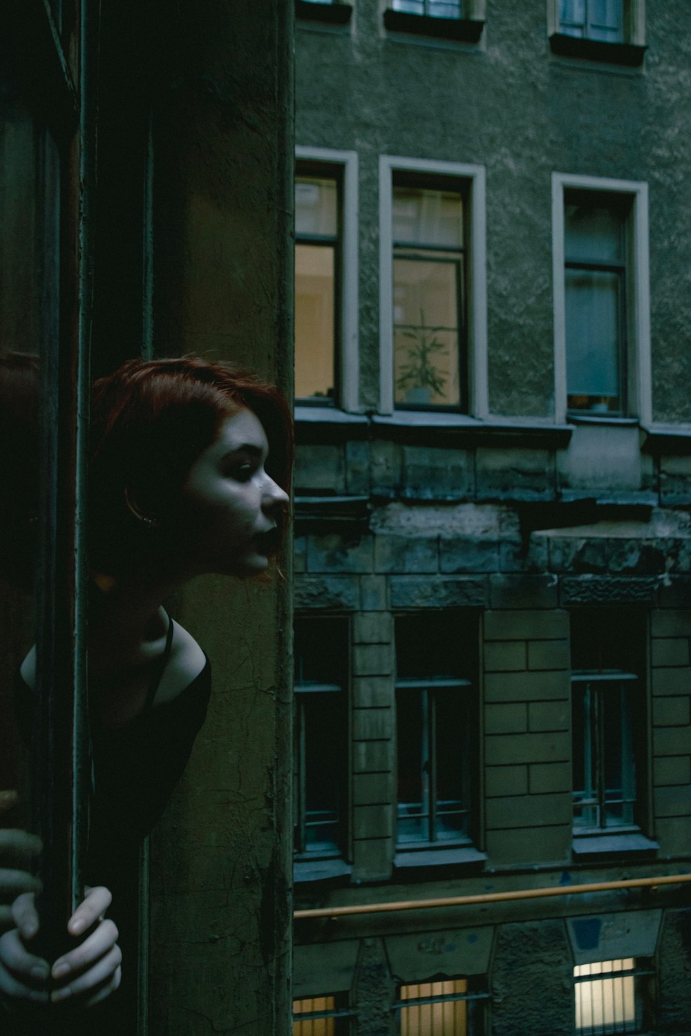 woman in black shirt standing beside window