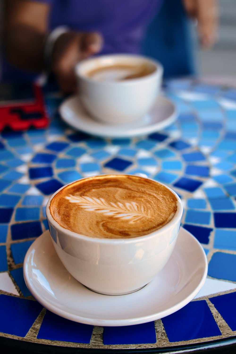 taza de cerámica blanca con capuchino