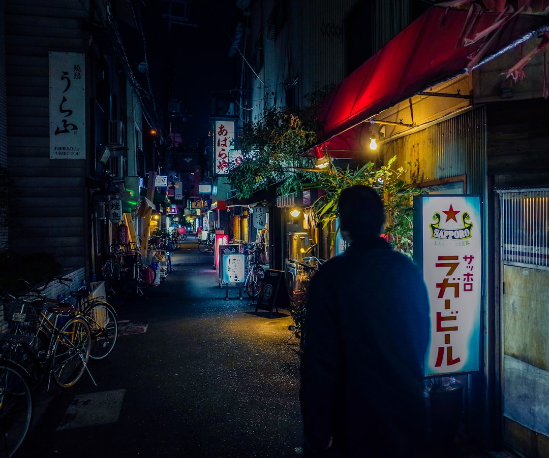 man in black jacket walking on street during nighttime