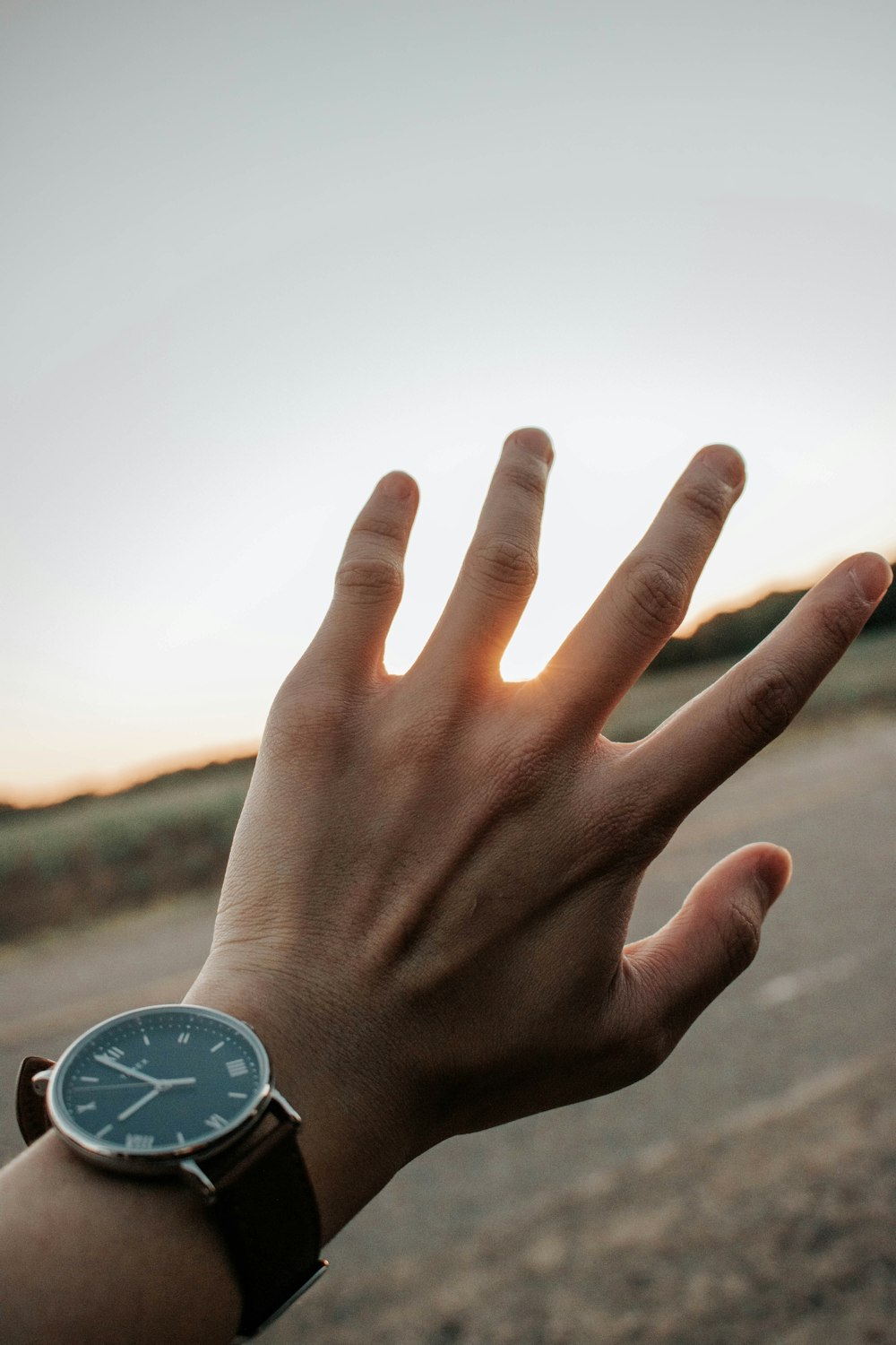 person wearing silver round analog watch