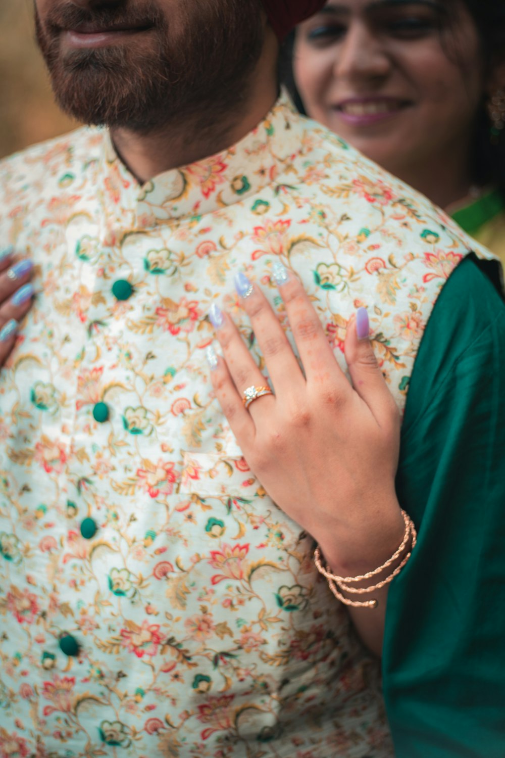 person in green shirt with white and pink floral dress