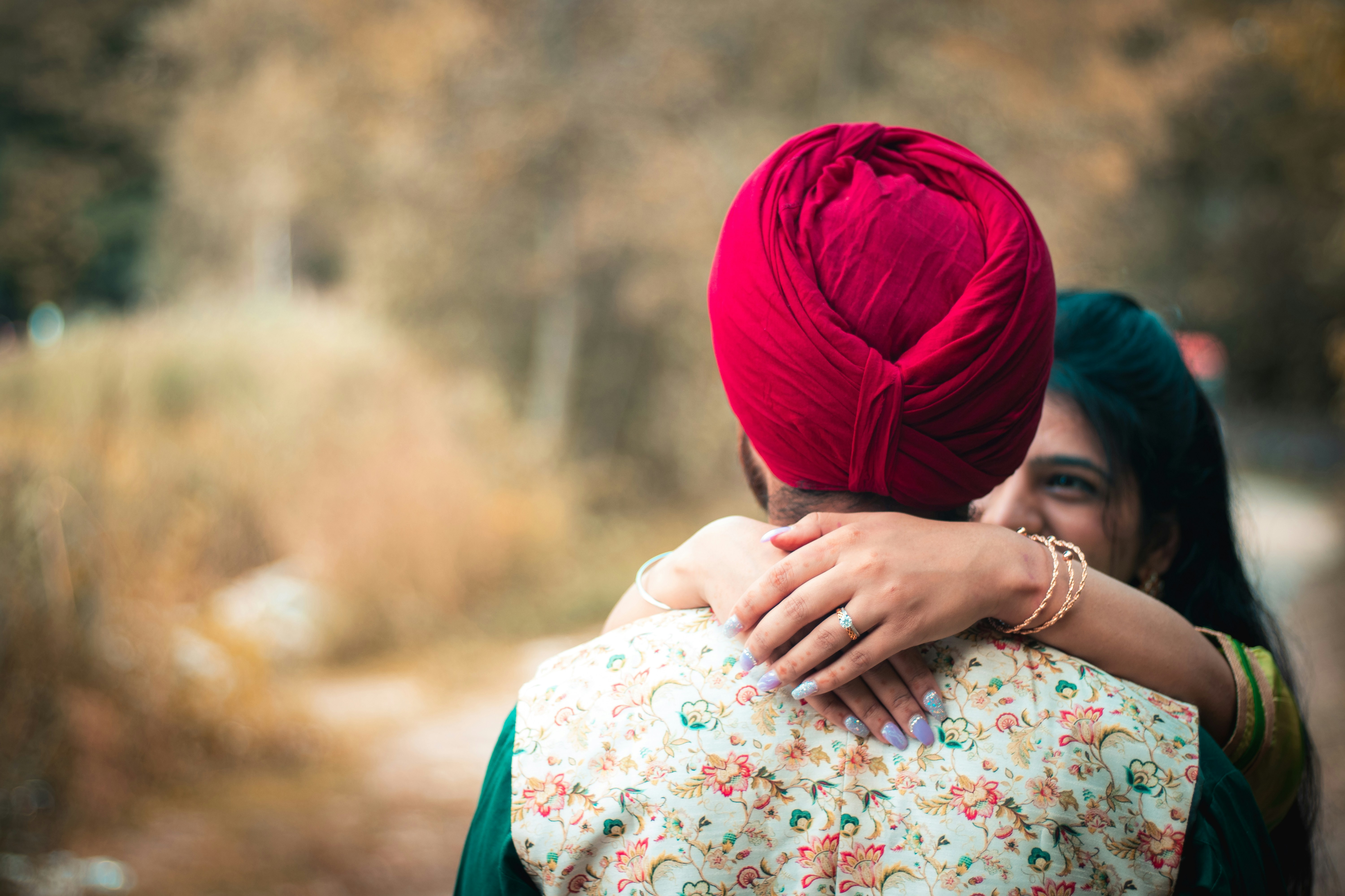 woman in white pink and green floral dress with blue hijab
