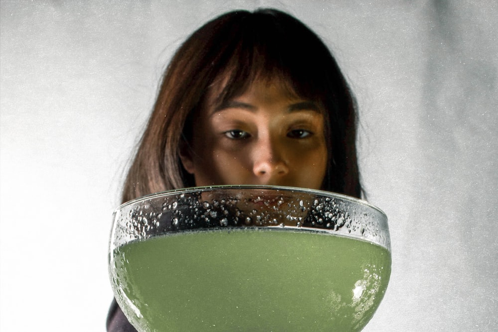 woman in white shirt holding green ceramic bowl