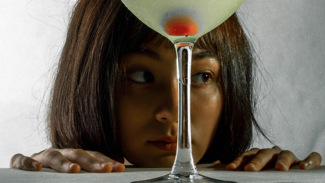 woman holding clear wine glass