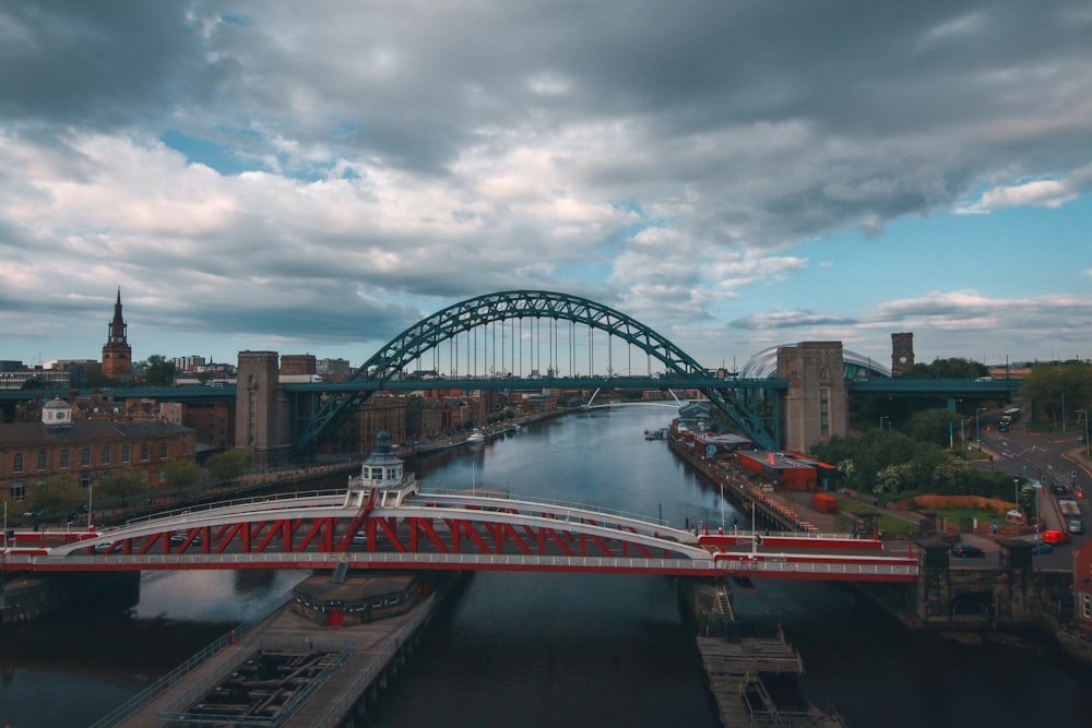 red and white bridge under cloudy sky