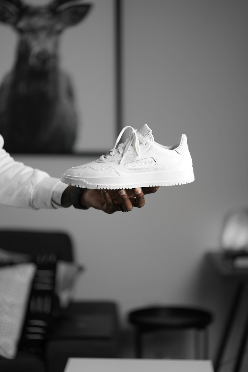 person holding white nike air force 1 low