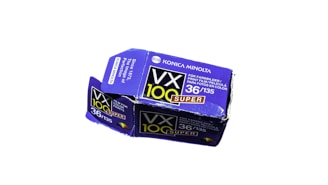 A small, rectangular box with purple and black coloring. The box displays the text 'Konica Minolta' and 'VX 100 Super' along with specifications '36/135'. It appears to be packaging for photographic film.