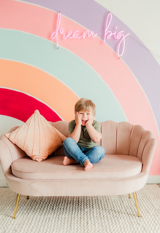 woman in blue denim jeans sitting on beige sofa chair