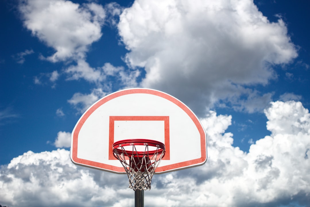 white and blue basketball hoop under cloudy sky during daytime