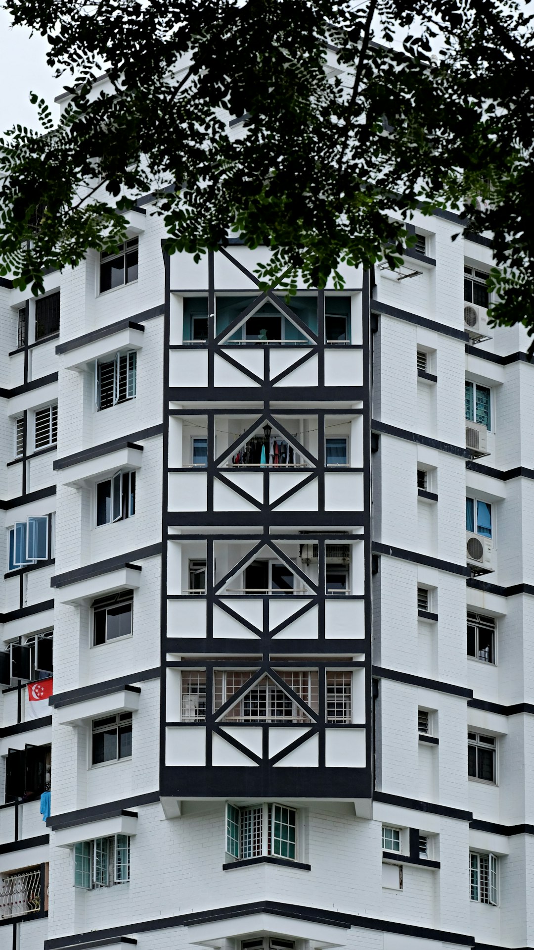 white concrete building with green trees in front