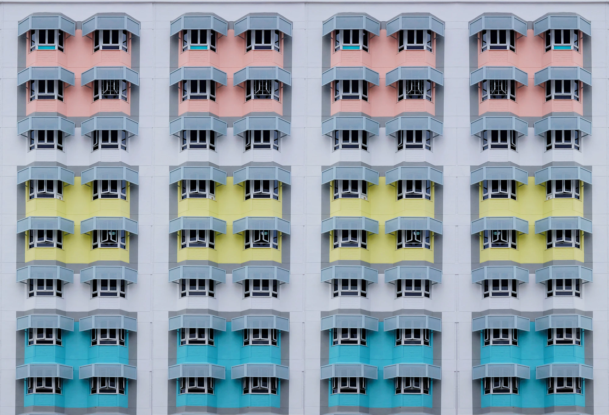 A facade of identical windows in pastel colours