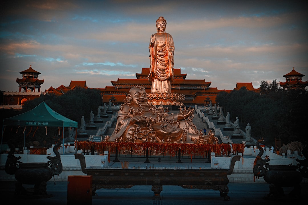 gold buddha statue near brown and black temple during daytime