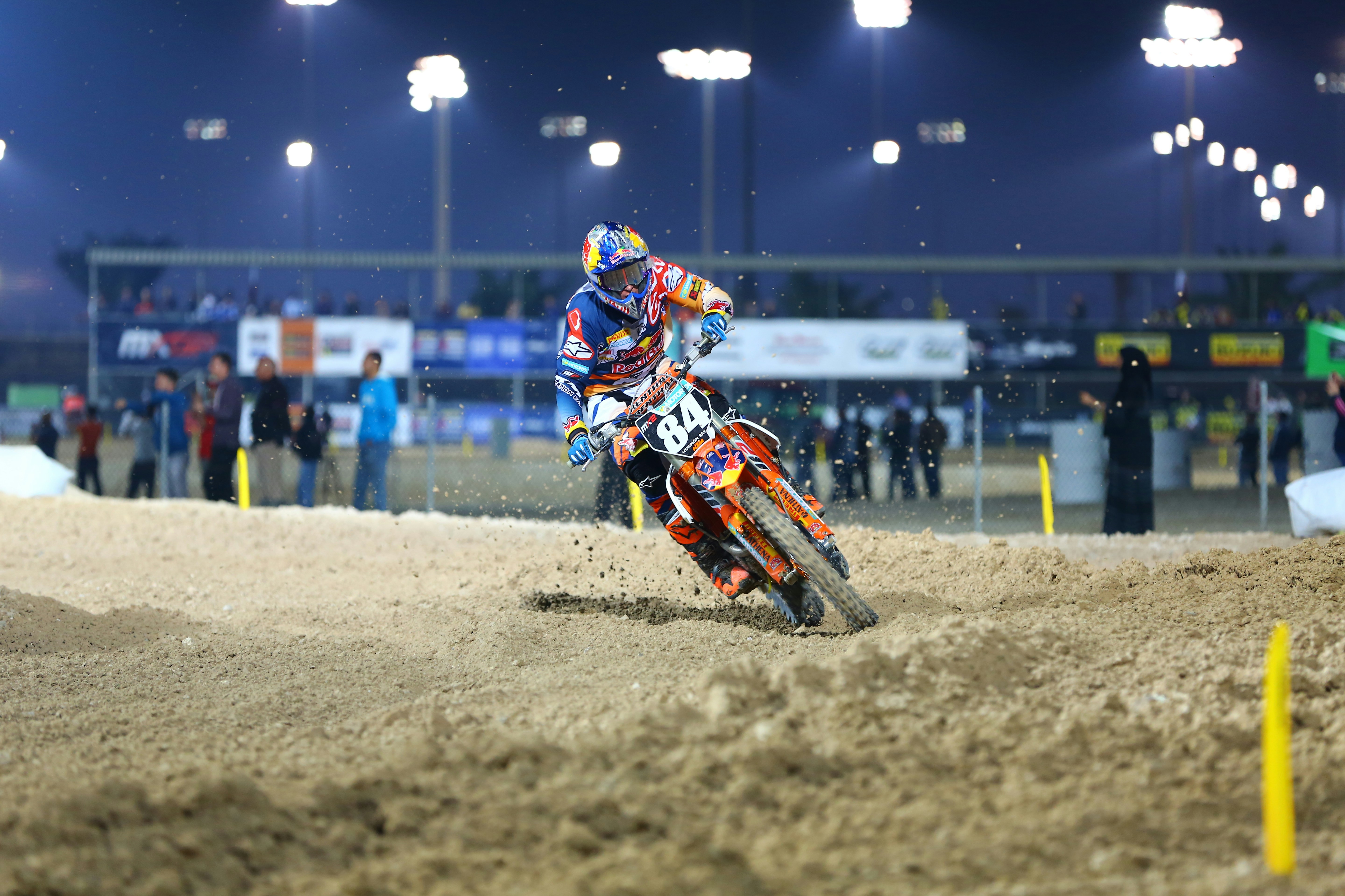 man in blue and white jacket riding orange motocross dirt bike during nighttime