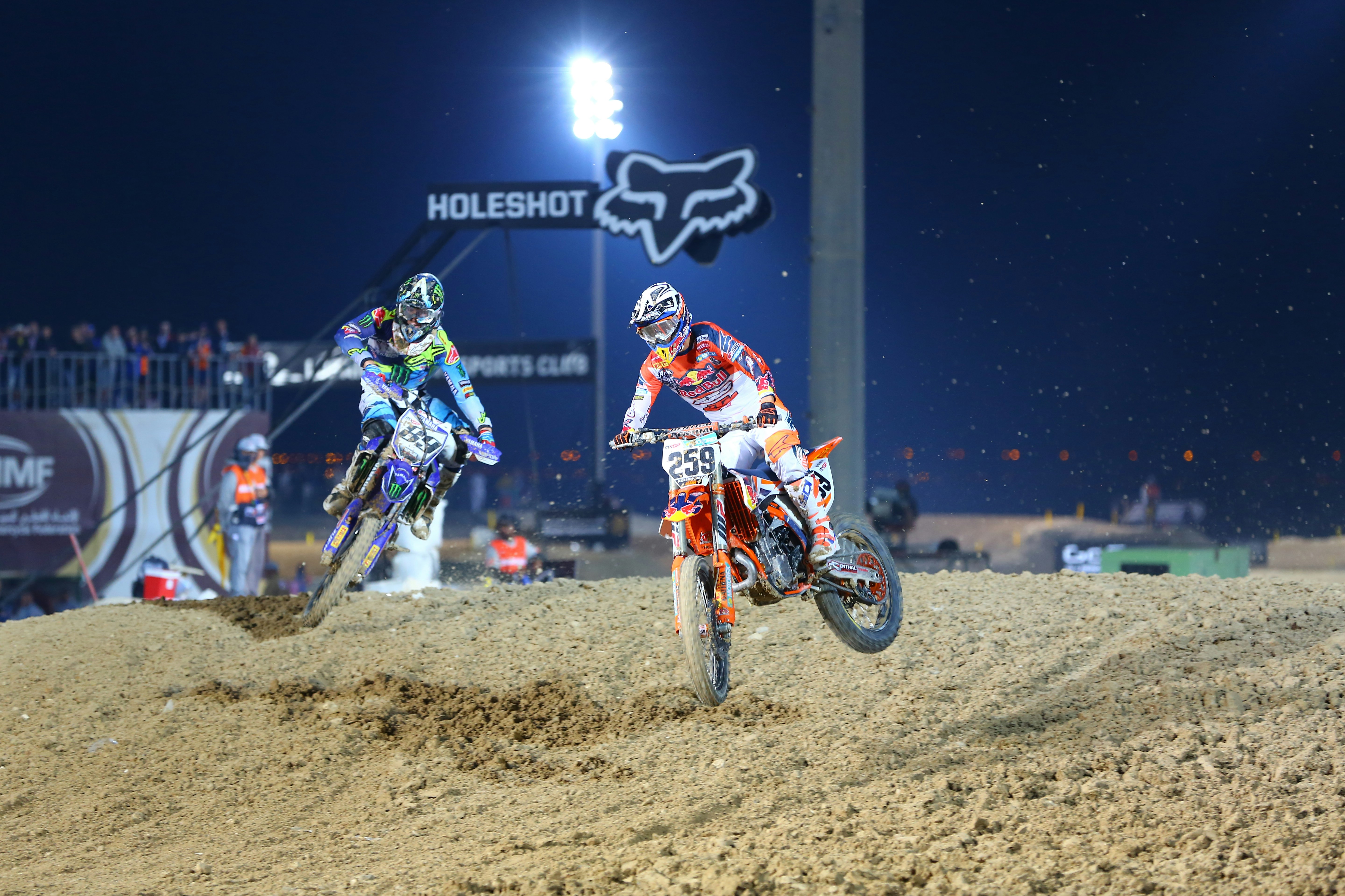 Pria bersetelan motorcross merah dan putih mengendarai sepeda motor trail