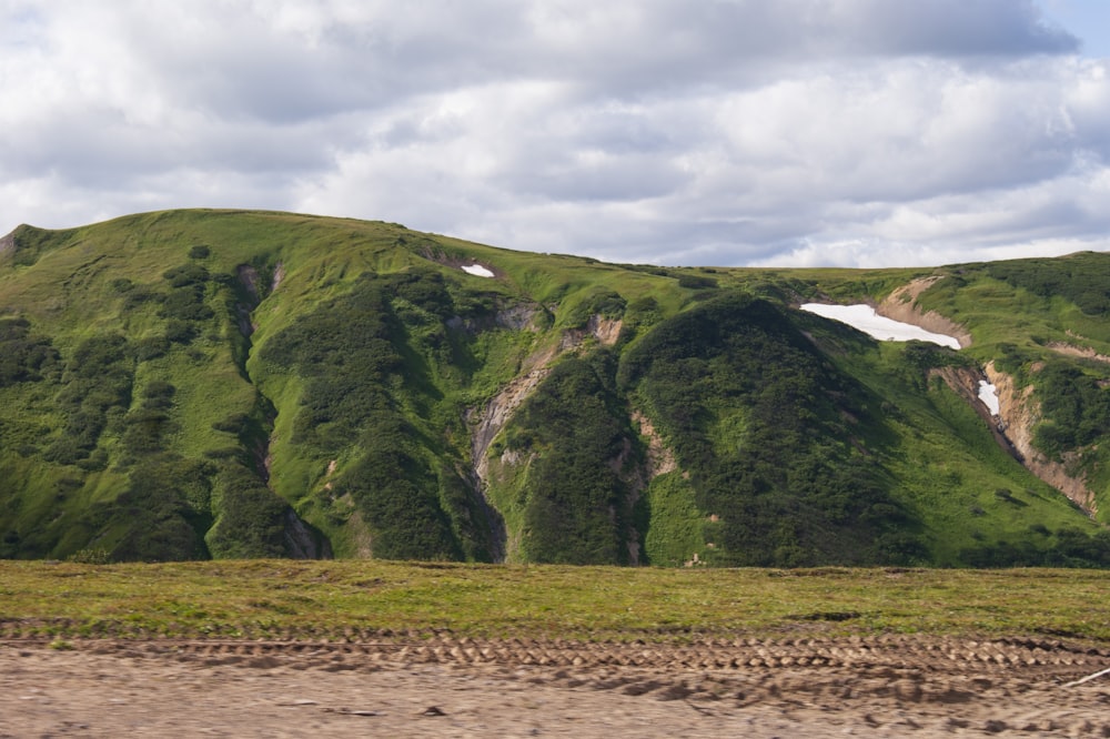 green and brown mountain under white clouds during daytime