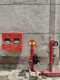 red fire extinguisher mounted on gray concrete wall