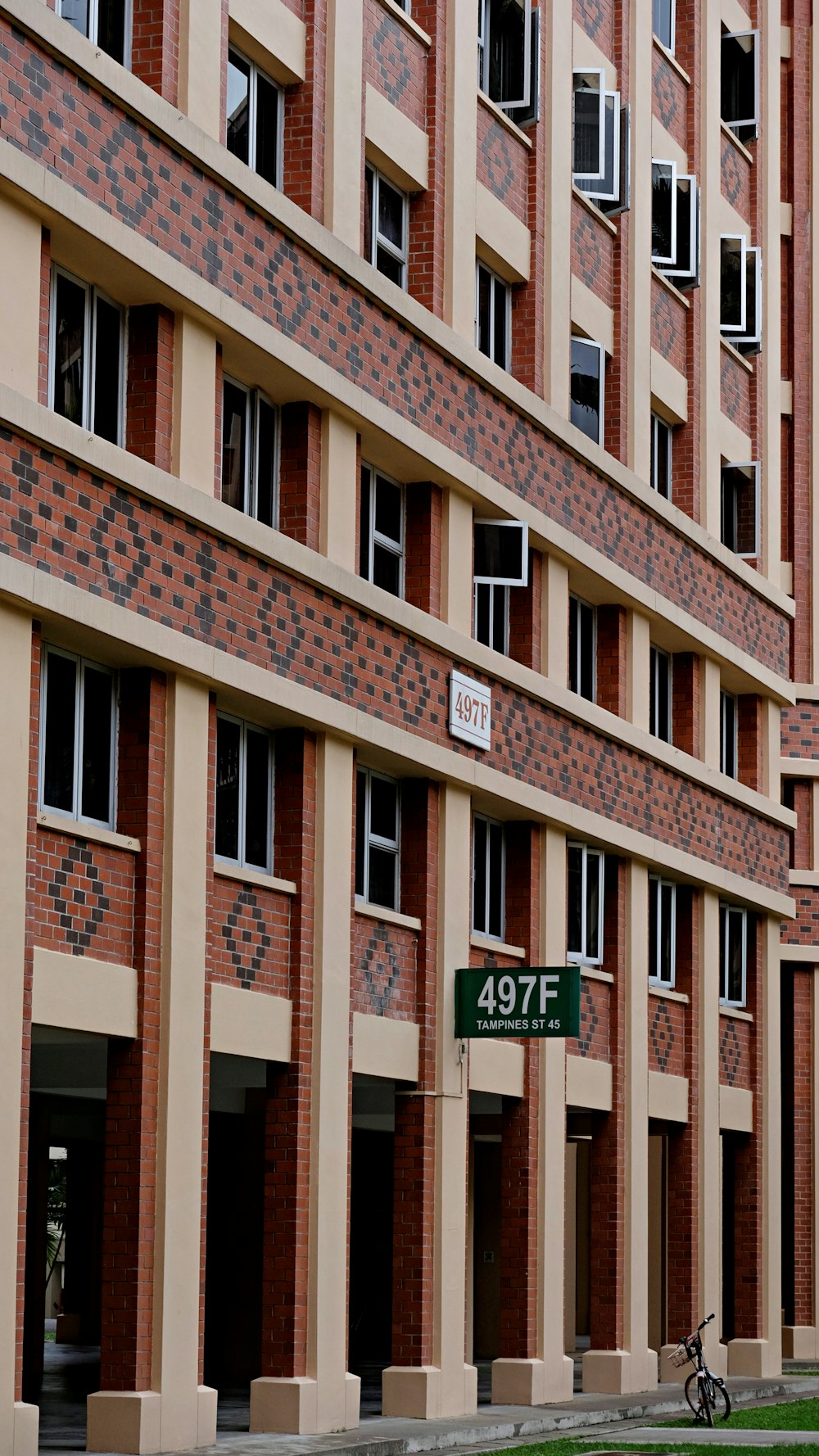 brown concrete building with green and white signage