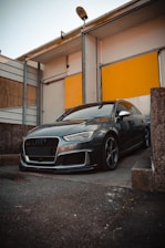 A sleek Jaecoo car parked in front of the Jaecoo Kuningan dealership building.