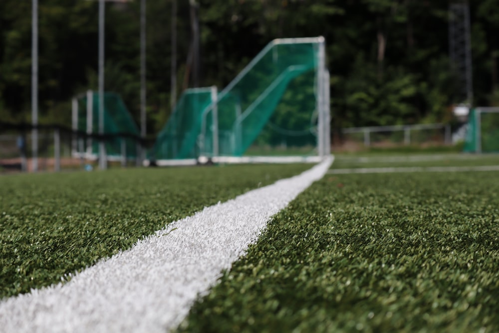 white and blue soccer goal net on green grass field during daytime