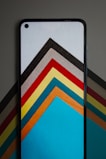 A modern smartphone showcasing a bold wallpaper with black, white, and gold geometric patterns