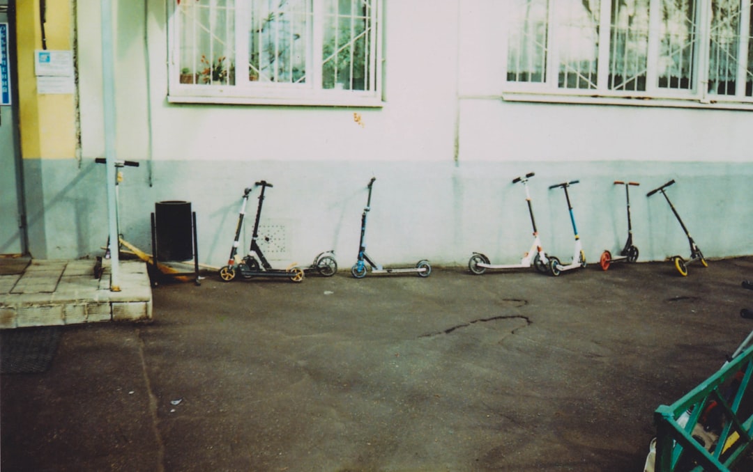 black and red kick scooter beside white wall