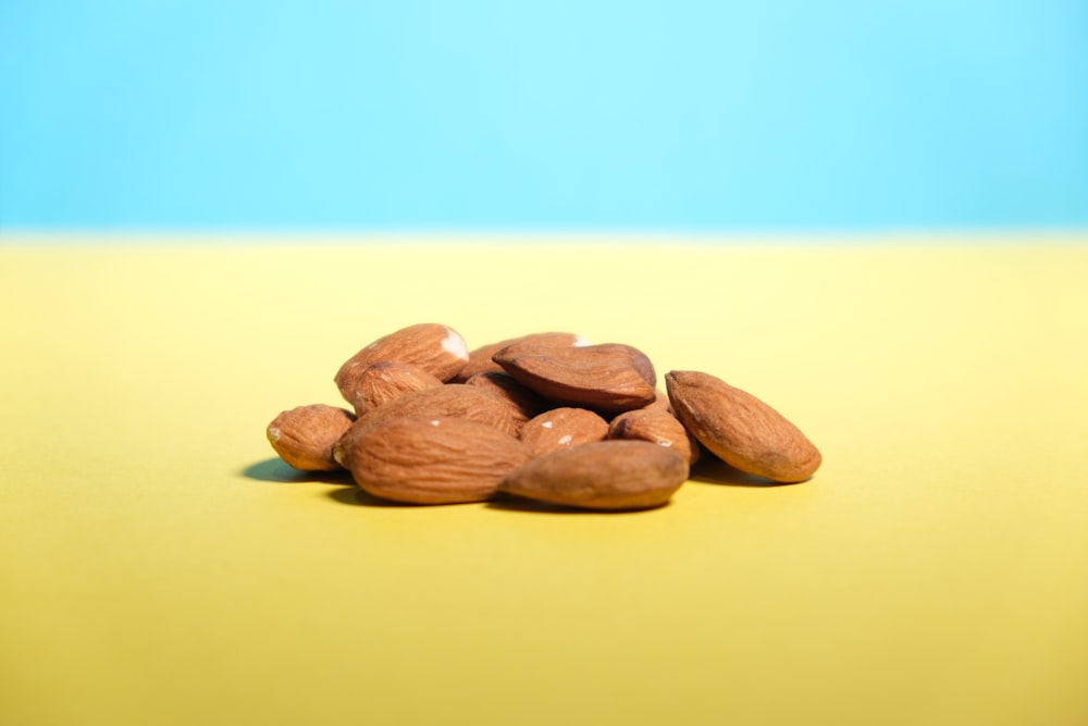 brown almond nuts on yellow surface
