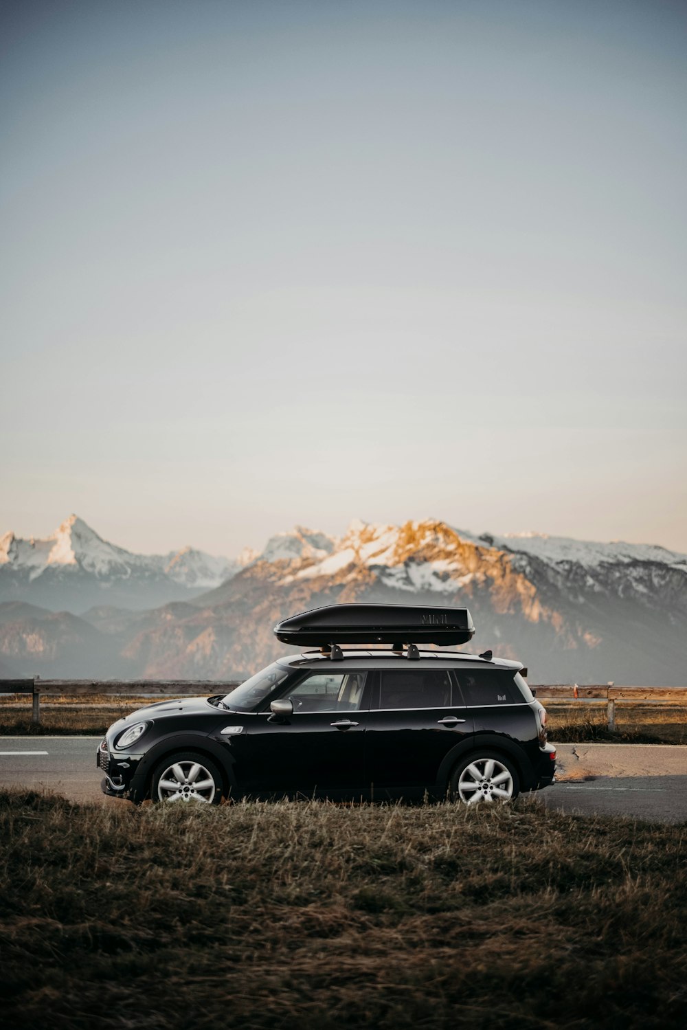 昼間、山の近くの未舗装の道路を走る黒いSUV