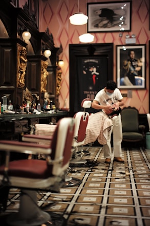 man in white t-shirt sitting on barber chair