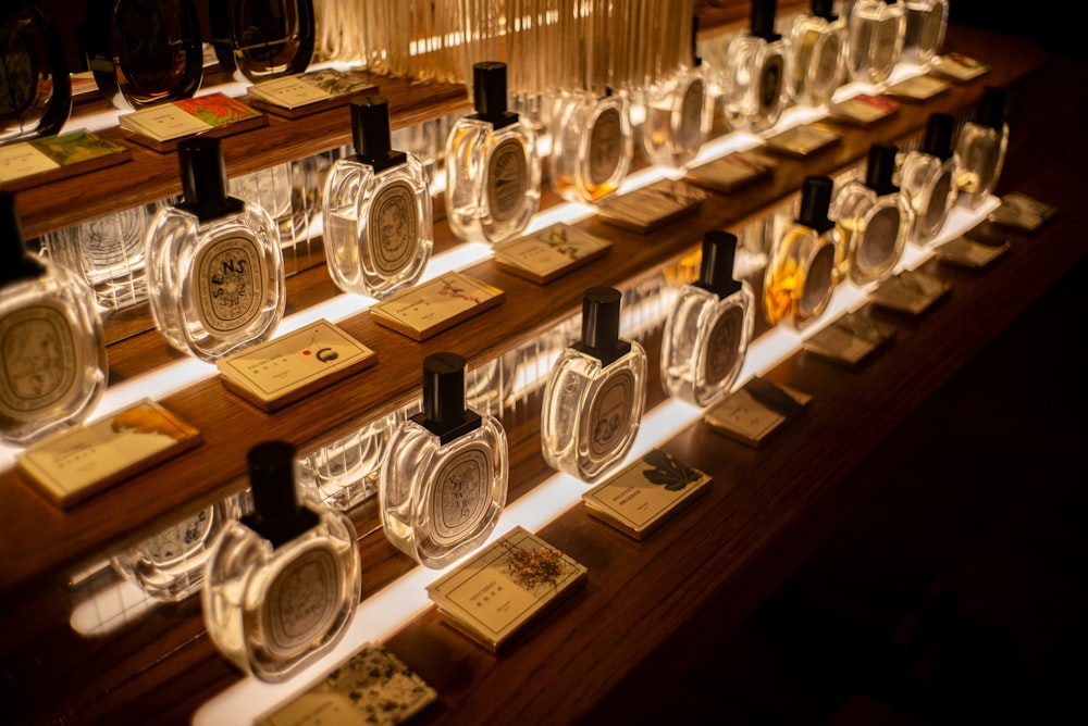 clear glass bottles on brown wooden shelf