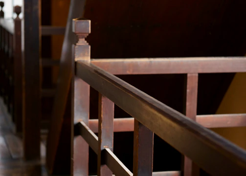 Close-up of a craftsman installing a new wooden stair railing with precision.