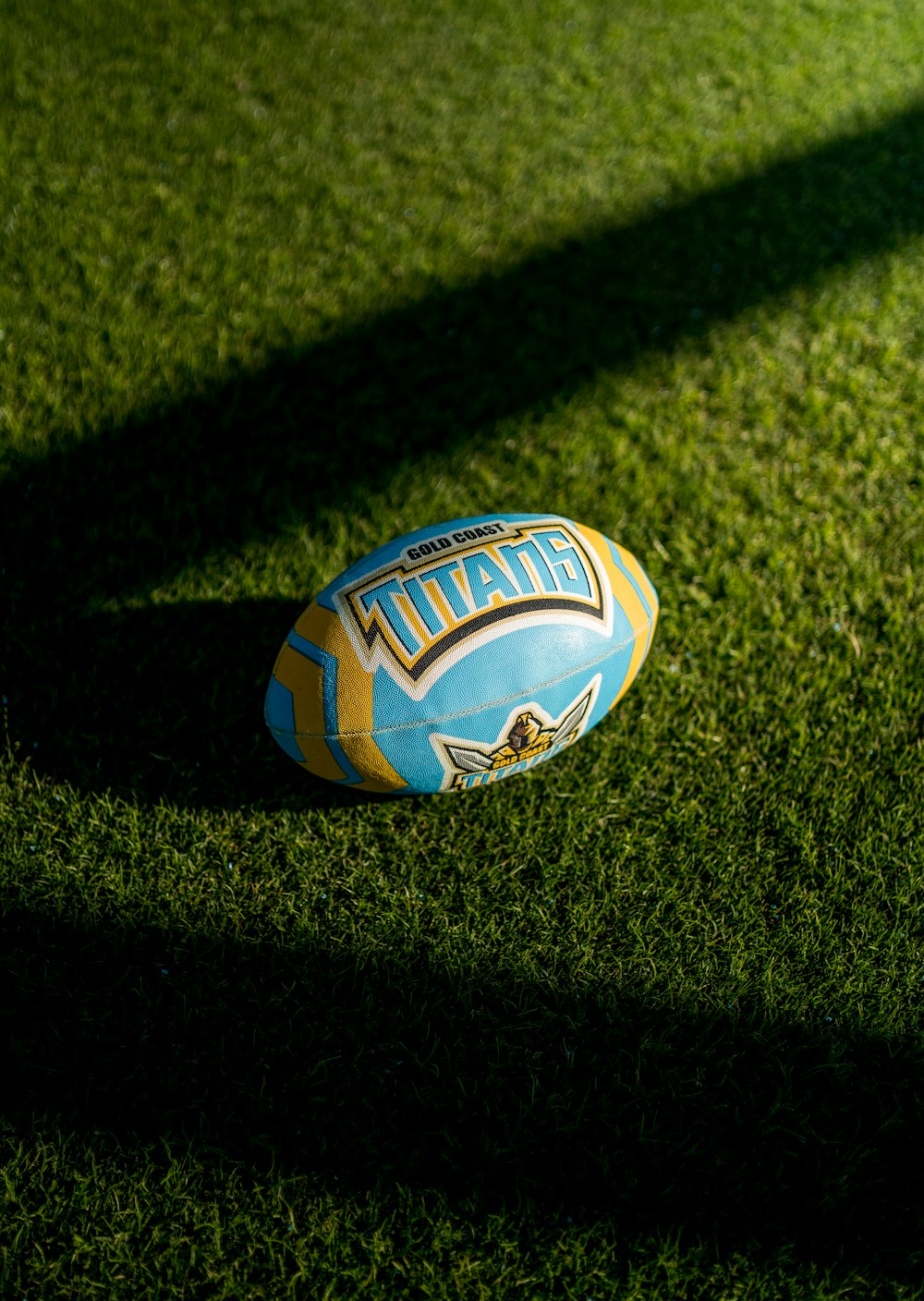 blau-weißer und orangefarbener Fußball auf grünem Rasenplatz