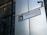 A street sign labeled 'HOUNDSDITCH EC3' is mounted on a modern building with reflective glass panels. The sign includes the City of London emblem. A security camera is positioned above the sign.