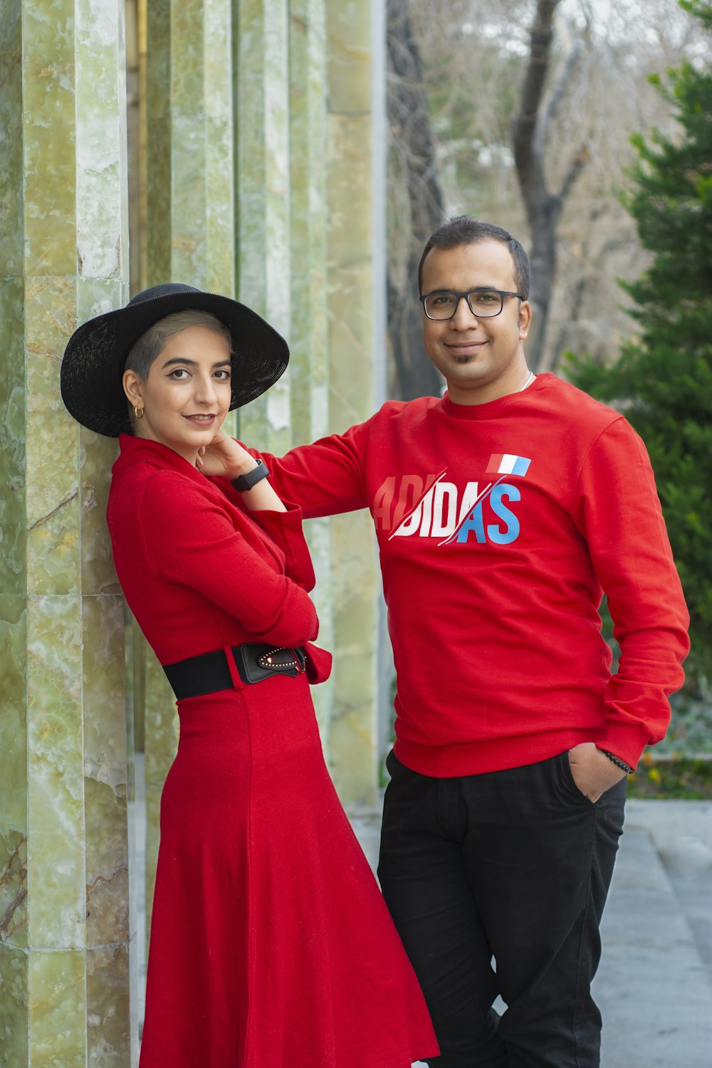 woman in red long sleeve shirt and black pants wearing black hat