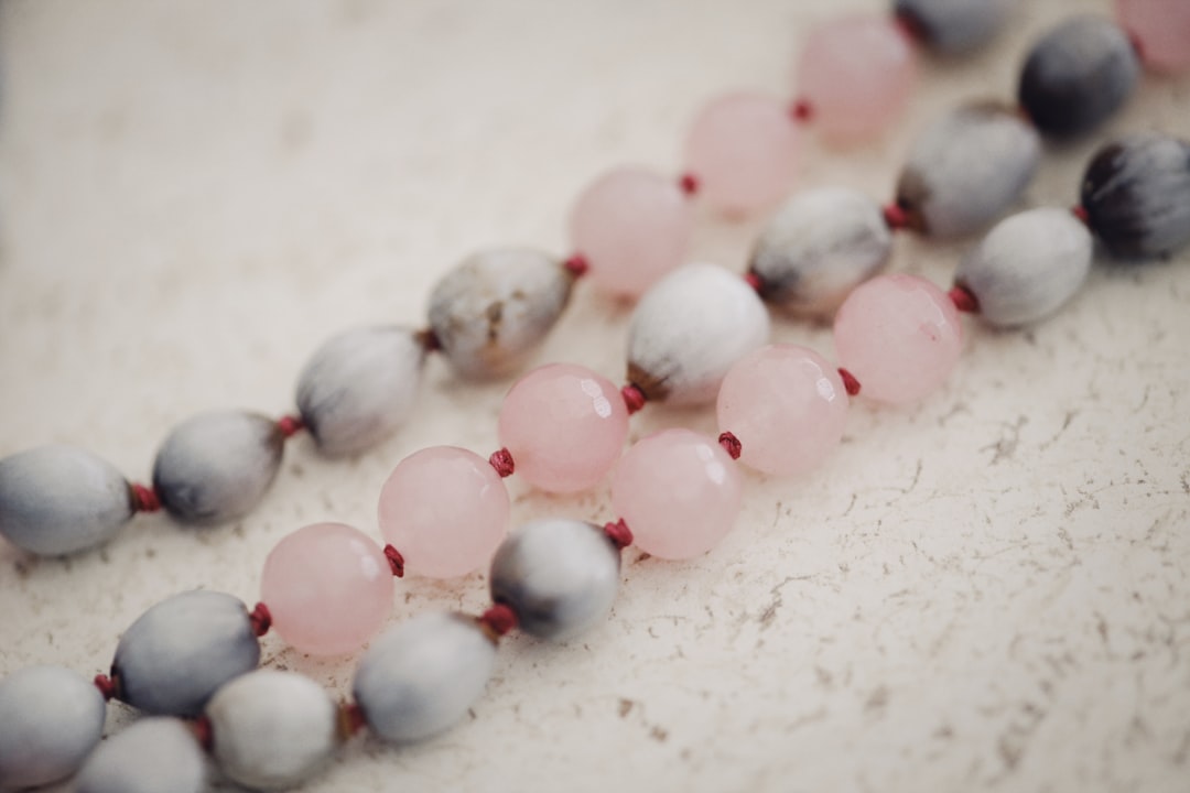 white and pink beads on white surface