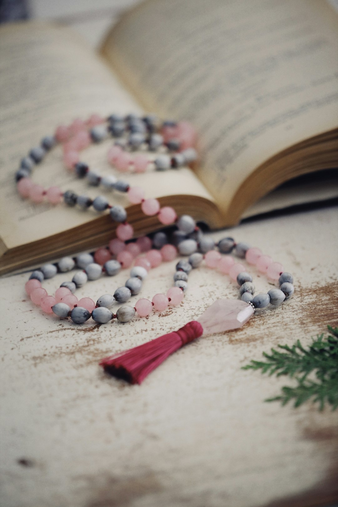 white and pink beaded necklace on brown wooden table
