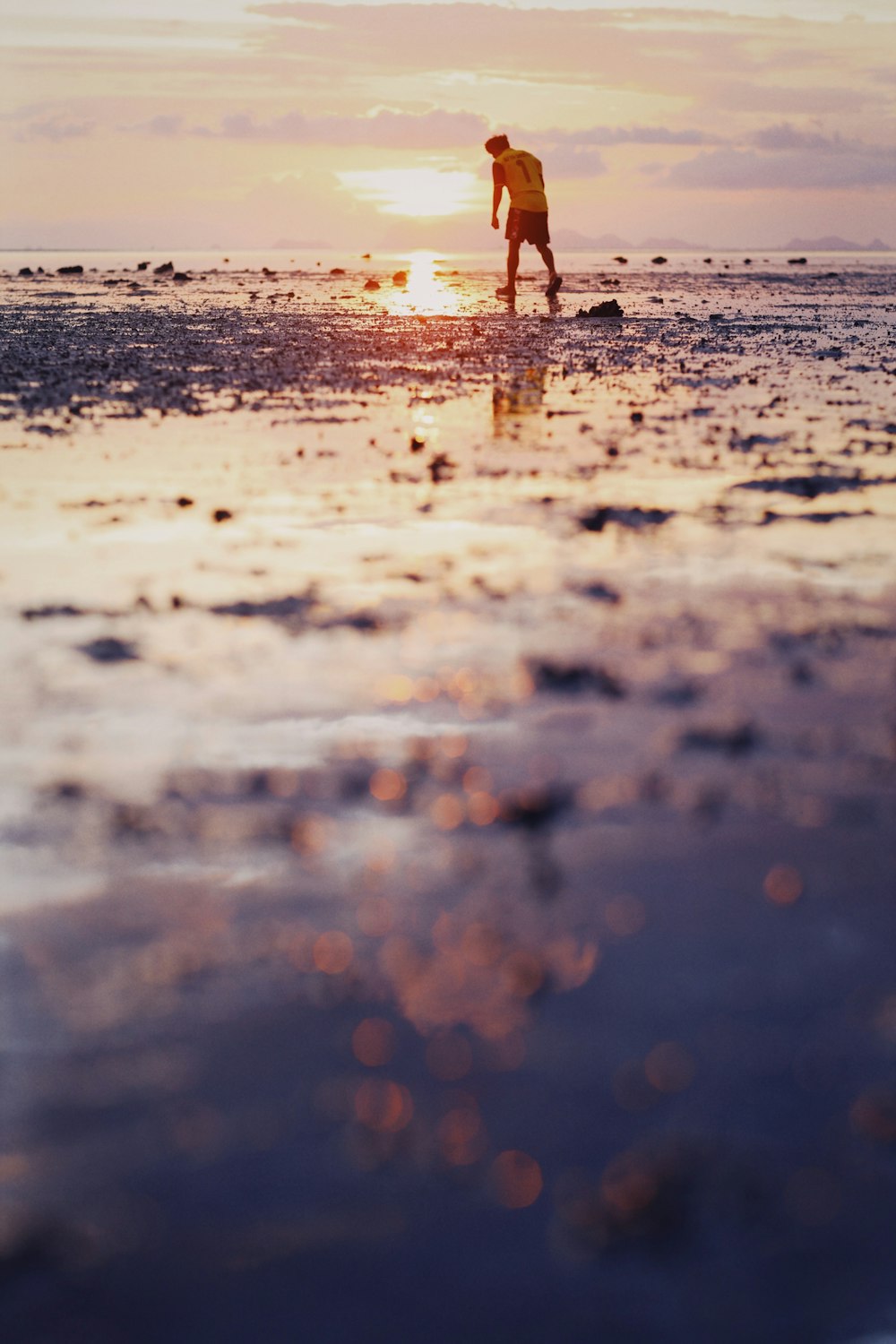 person walking on wet sand during daytime