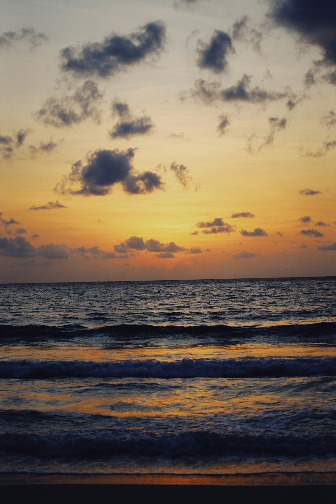 sea waves crashing on shore during sunset