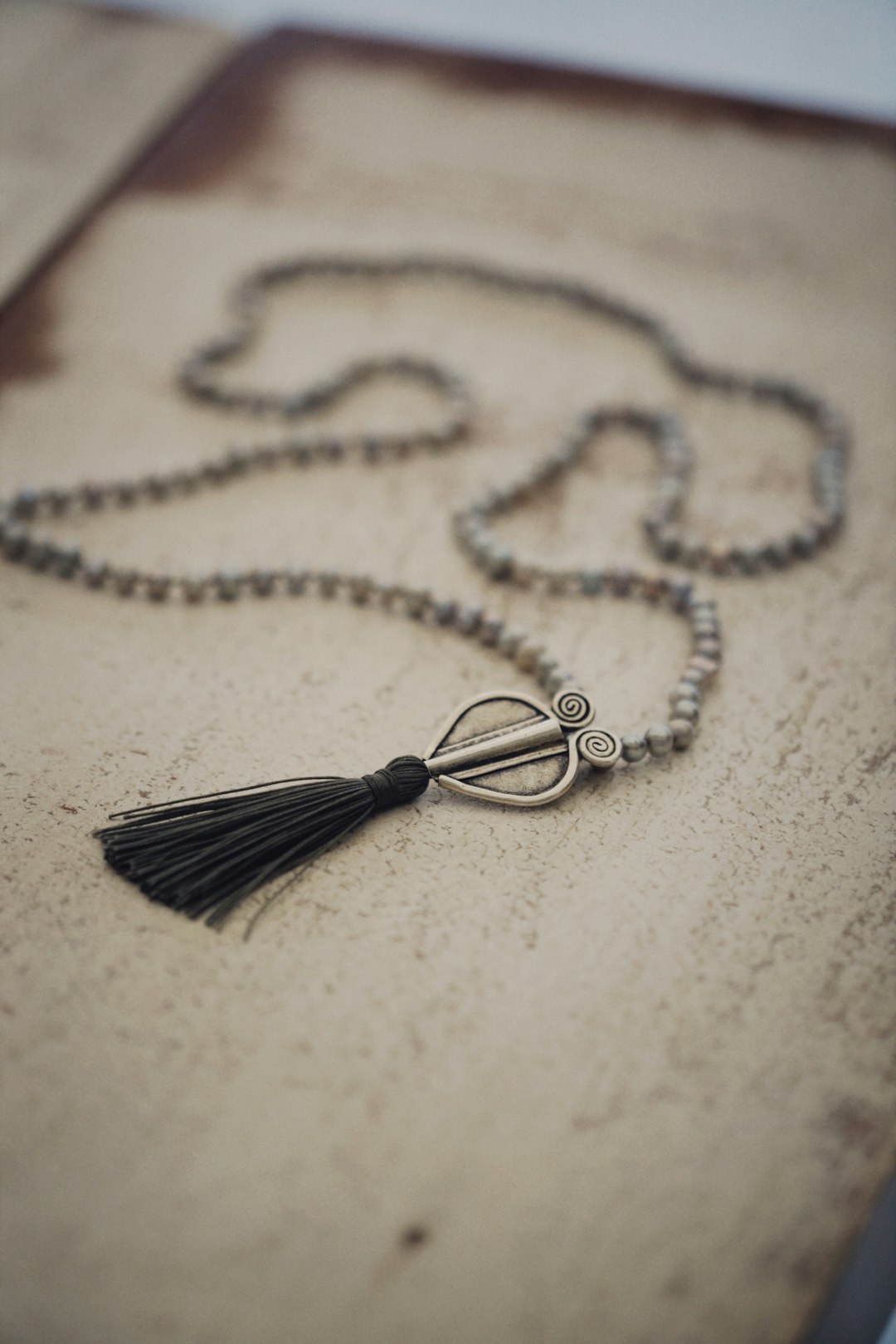 silver necklace on white textile