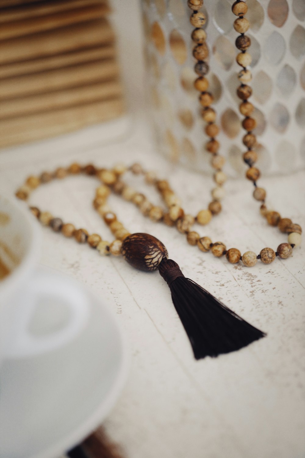 gold beaded necklace on white table