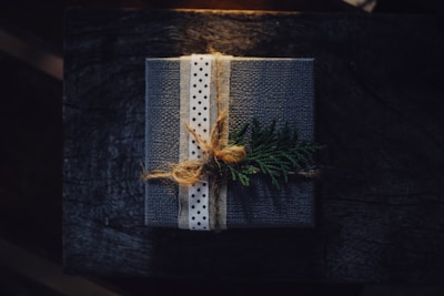 A cozy wrapped gift box with a delicate ribbon on a rustic wooden table.