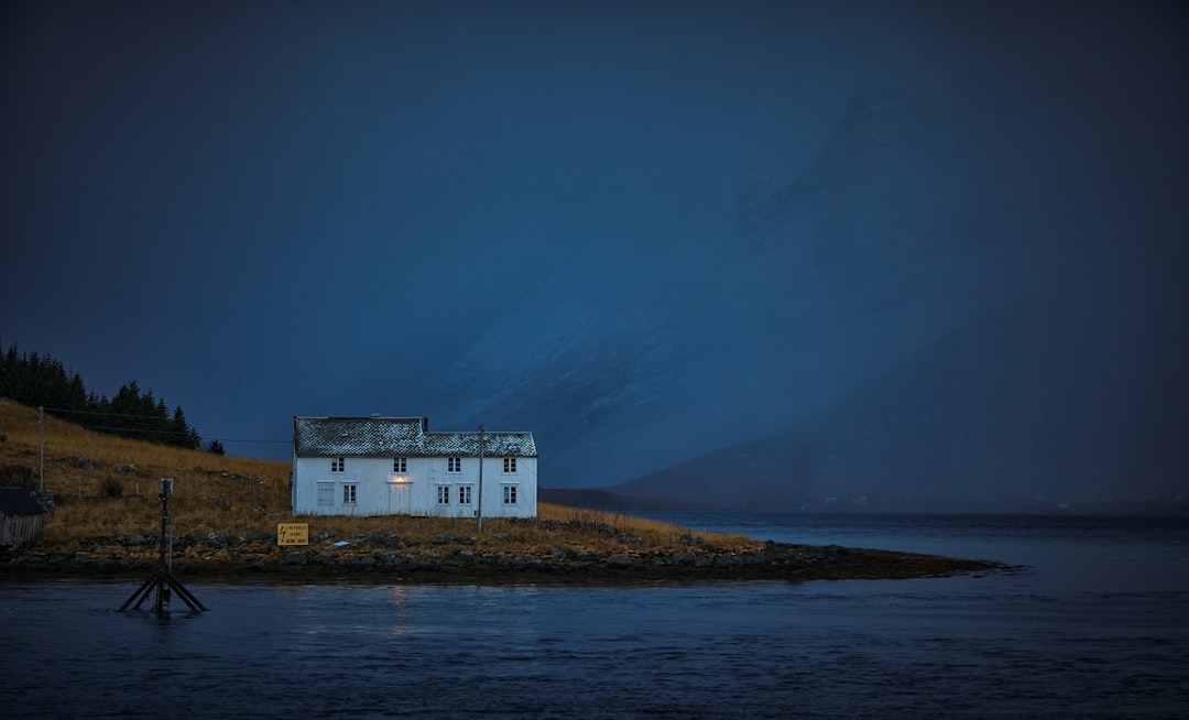 white concrete building on hill near body of water