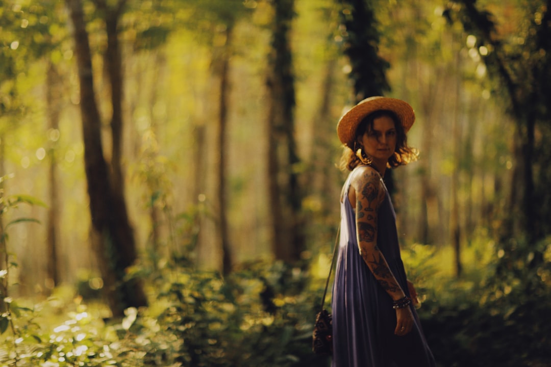 woman in black dress standing on forest during daytime