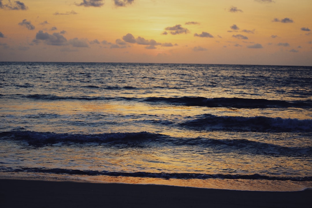 ocean waves crashing on shore during sunset