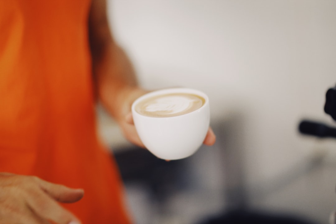 person holding white ceramic mug