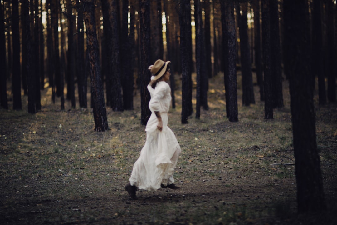 woman in white dress walking on forest during daytime